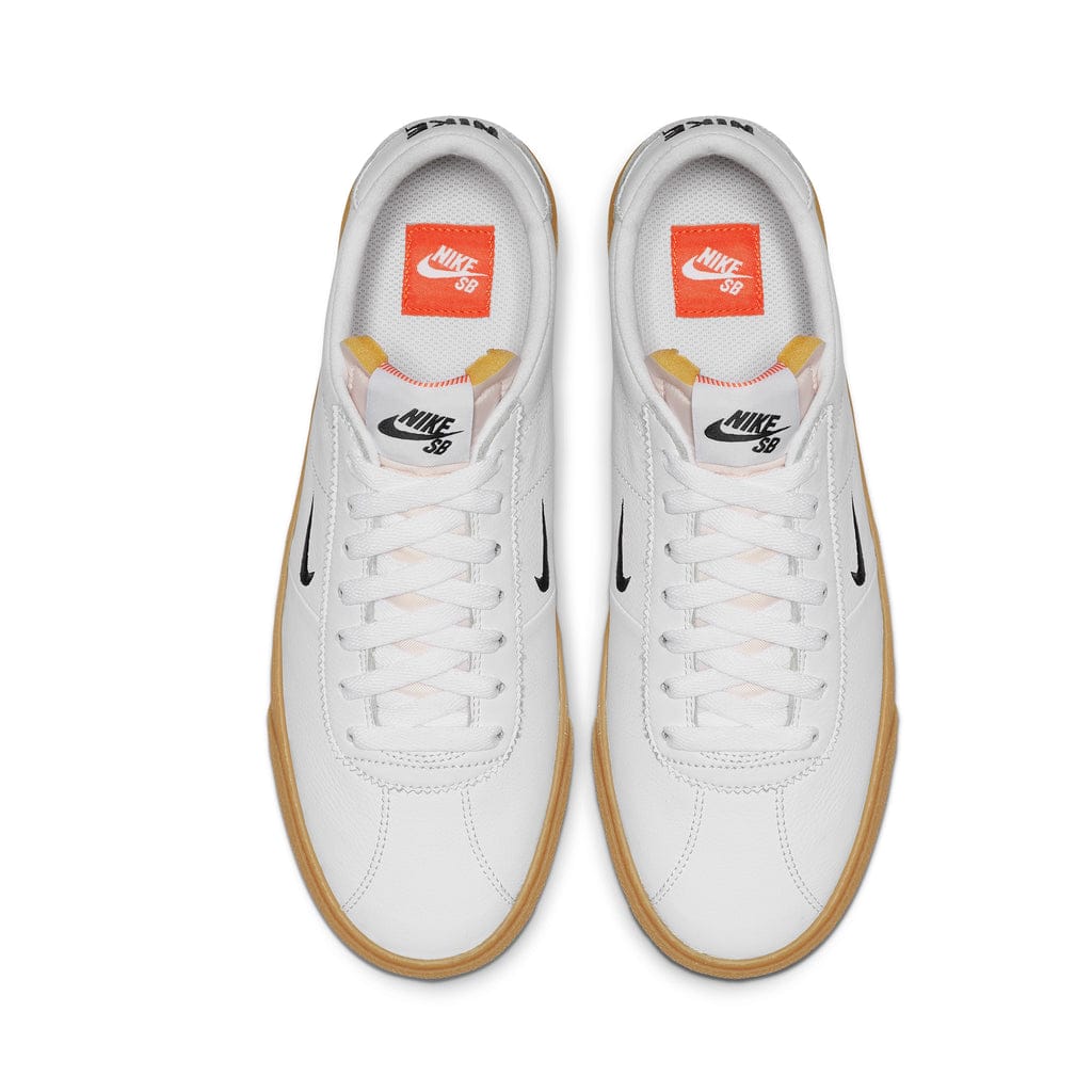 nike sb orange label bruin shoes, white leather, black nike swoosh, gum sole, white background, top view